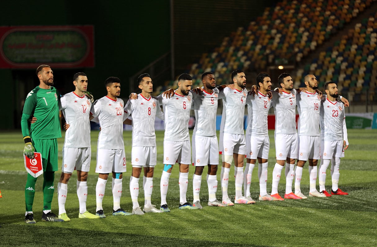 L’équipe nationale de football tunisienne chante l’hymne pendant le match de football de qualification pour la Coupe d’Afrique des Nations (AFCON) 2021 entre la Libye et la Tunisie dans la ville de Benghazi, dans l’est de la Libye, le 25 mars 2021. © AFP