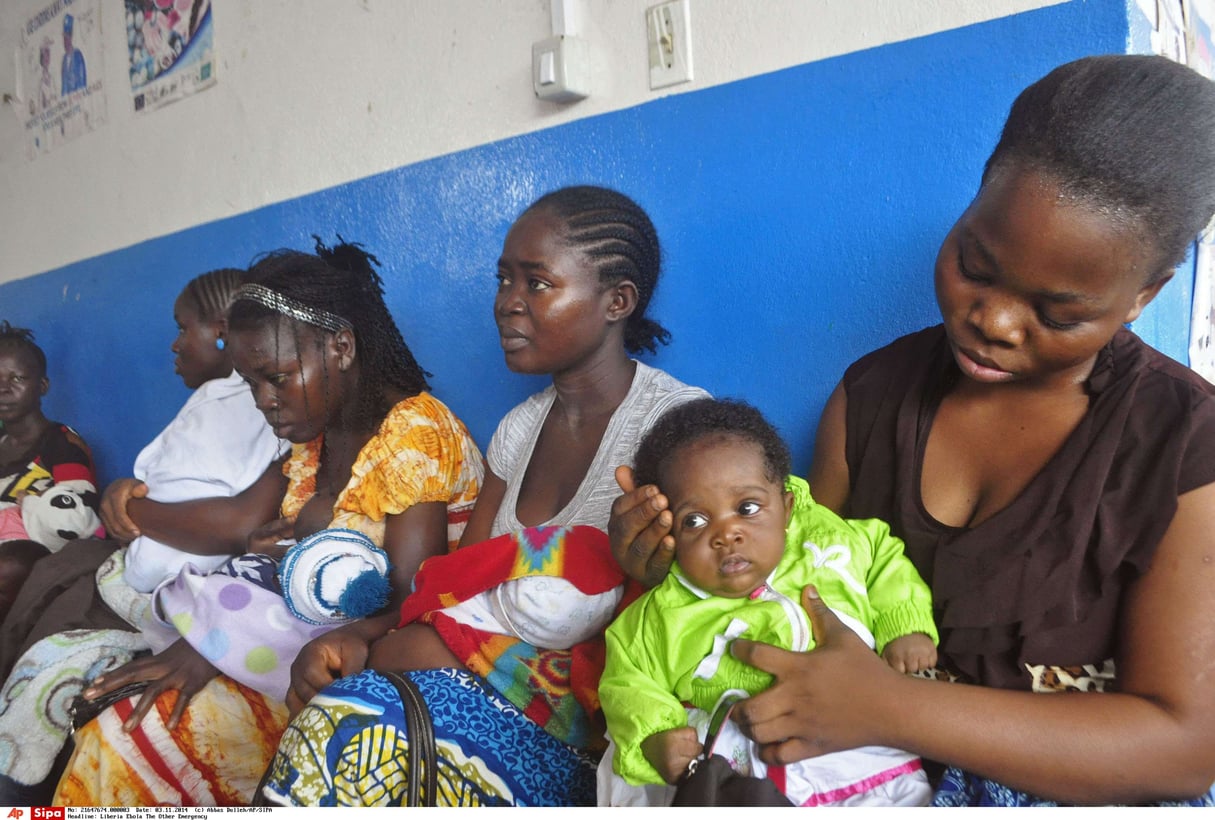 Des mères font la queue pour que leurs enfants soient vaccinés au centre de santé communautaire de Pipeline, situé dans la banlieue de Monrovia, au Liberia, en novembre 2014. © Abbas Dulleh/AP/SIPA