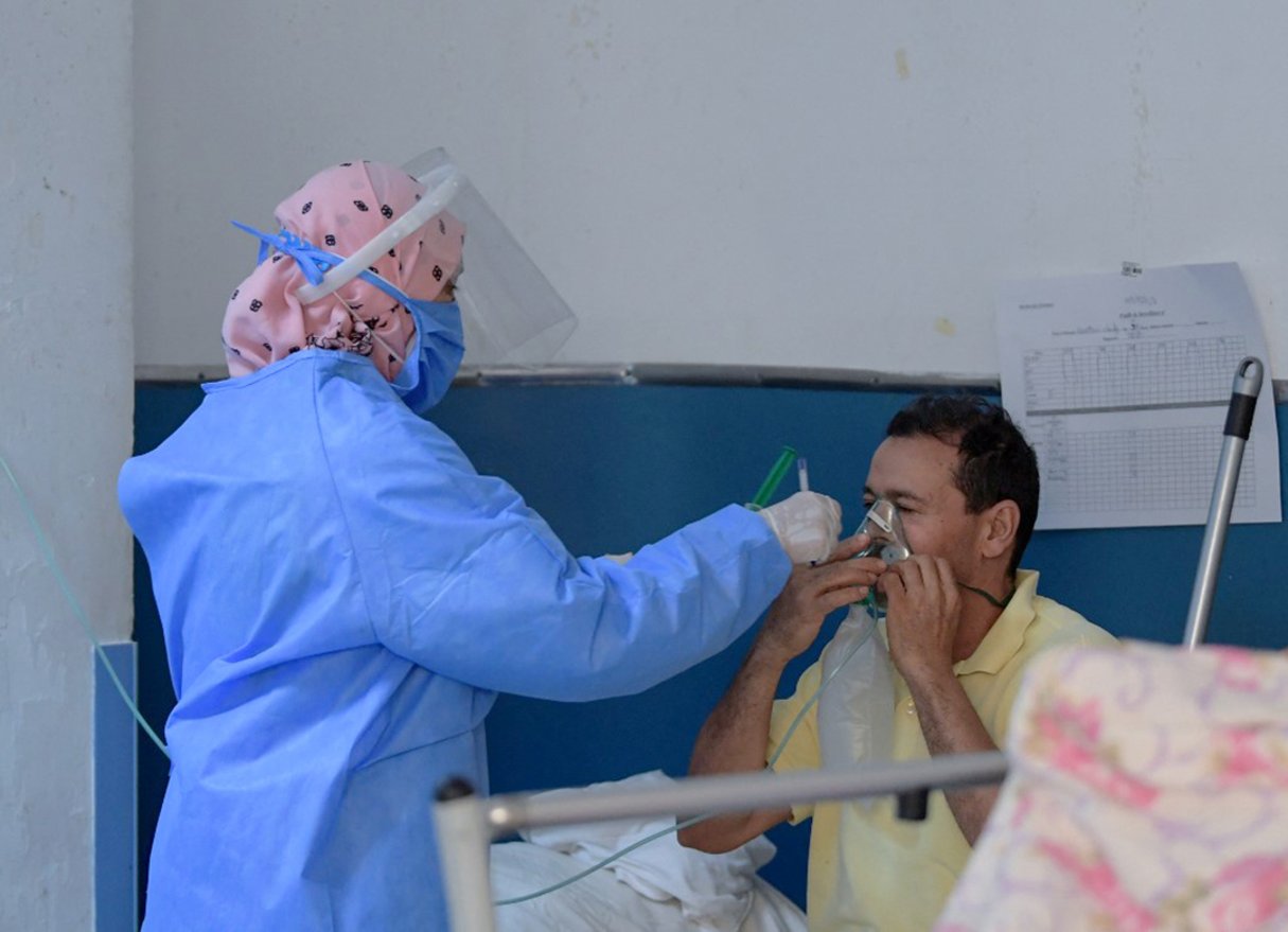 Un infirmier tunisien prodigue les premiers soins aux patients atteints de COVID-19 aux urgences de l’hôpital Charles Nicole de la capitale Tunis, le 16 juillet 2021. © FETHI BELAID/AFP