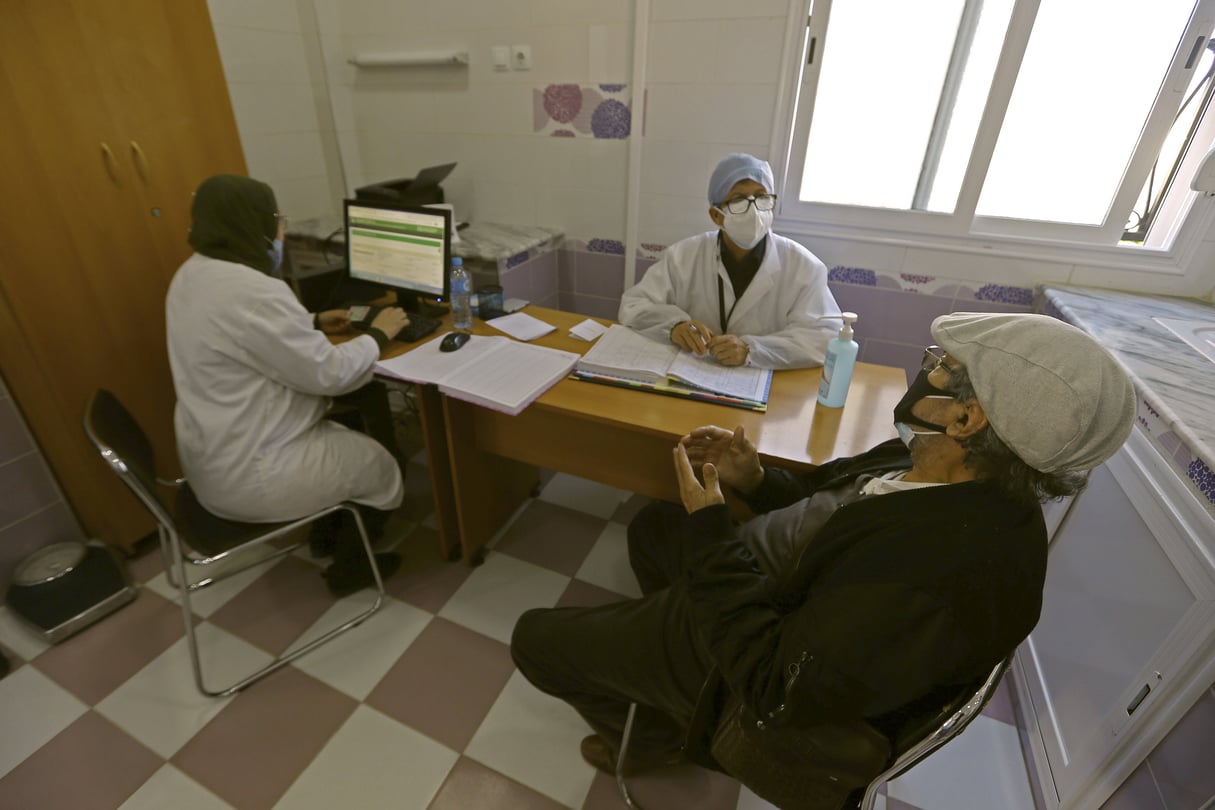 Un homme s’entretient avec des travailleurs médicaux pour prendre rendez-vous médical et se faire vacciner contre le COVID-19, mercredi 3 février 2021 à Alger.