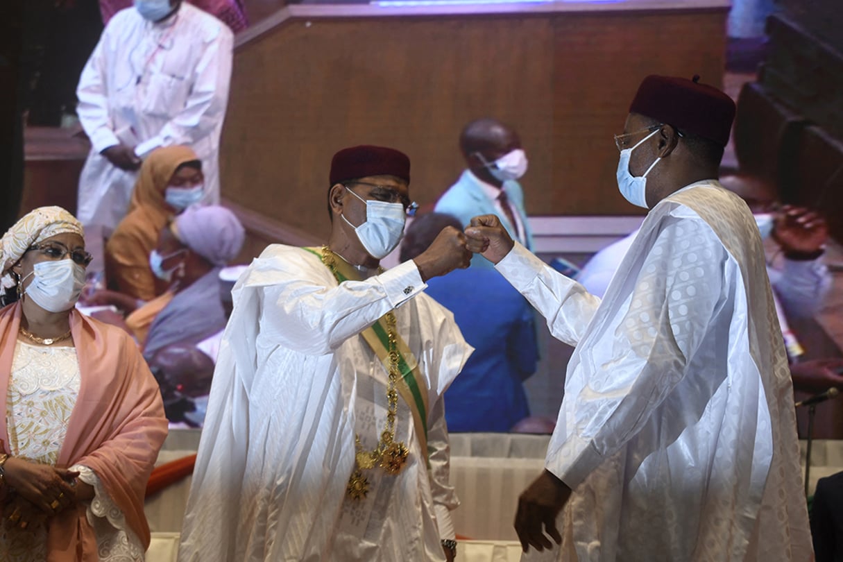 « Check » entre le nouveau président Mohamed Bazoum (g.) et son prédécesseur, Mahamadou Issoufou, lors de la cérémonie d’investiture, le 2 avril 2021, au Centre international de conférences de Niamey. © BOUREIMA HAMA / AFP