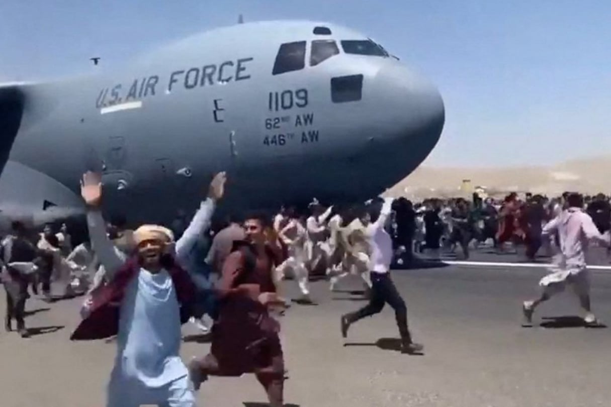Des centaines d’Afghans prennent d’assaut un avion de l’US Air Force pour tenter de fuir leur pays, à l’aéroport Hamid-Karzaï de Kaboul, le 16 août 2021 (capture d’écran d’une vidéo de la BBC). © Nicola Careem/BBC/EyePress News/AFP