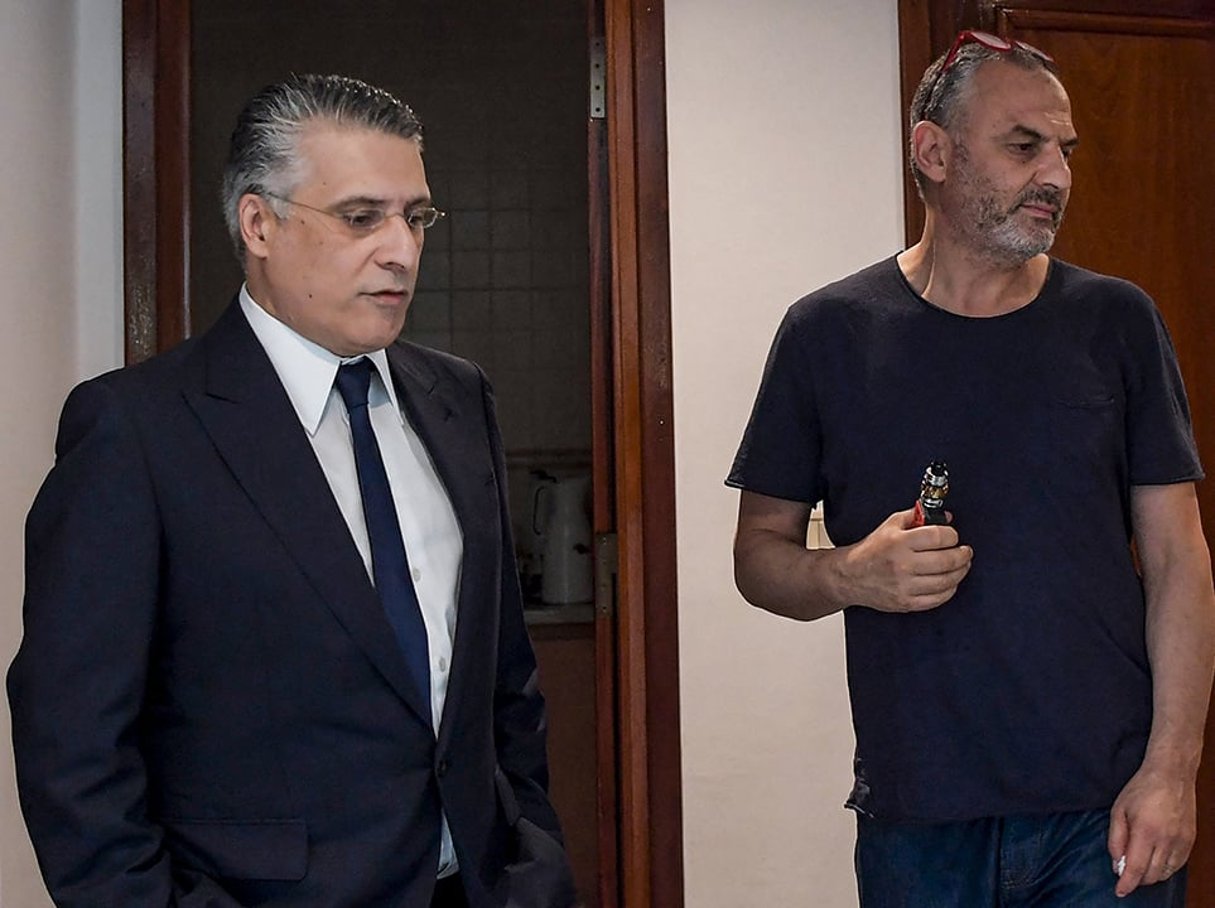 Nabil (à g.) et Ghazi Karoui, le 18 juin 2019, à Tunis. Tunisian media mogul Nabil Karoui (L) and his brother Ghazi look on while standing at the Qalb Tounes (Heart of Tunisia) party headquarters in the capital Tunis on June 18, 2019. – Tunisian authorities have arrested a controversial presidential candidate and founder of a major private television channel, Nabil Karoui, his political party said on August 23. Private radio station Mosaique FM quoted a judicial official confirming that Karoui was the subject of an arrest warrant. The 56-year-old tycoon was charged with money laundering in early July shortly after stating his intention to stand in the September 15 polls, but has remained a leading candidate. 
©FETHI BELAID / AFP