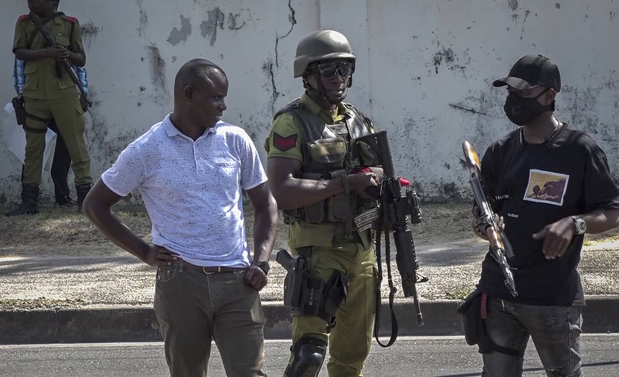 Capture d’écran d’une vidéo, où des services de sécurité se tiennent près d’une dépouille dans une rue, à proximité de l’ambassade de France à Dar es Salaam, en Tanzanie, le 25 août 2021. © AP Photo)/NAI104/21237699578618/Image made from video/2108252131