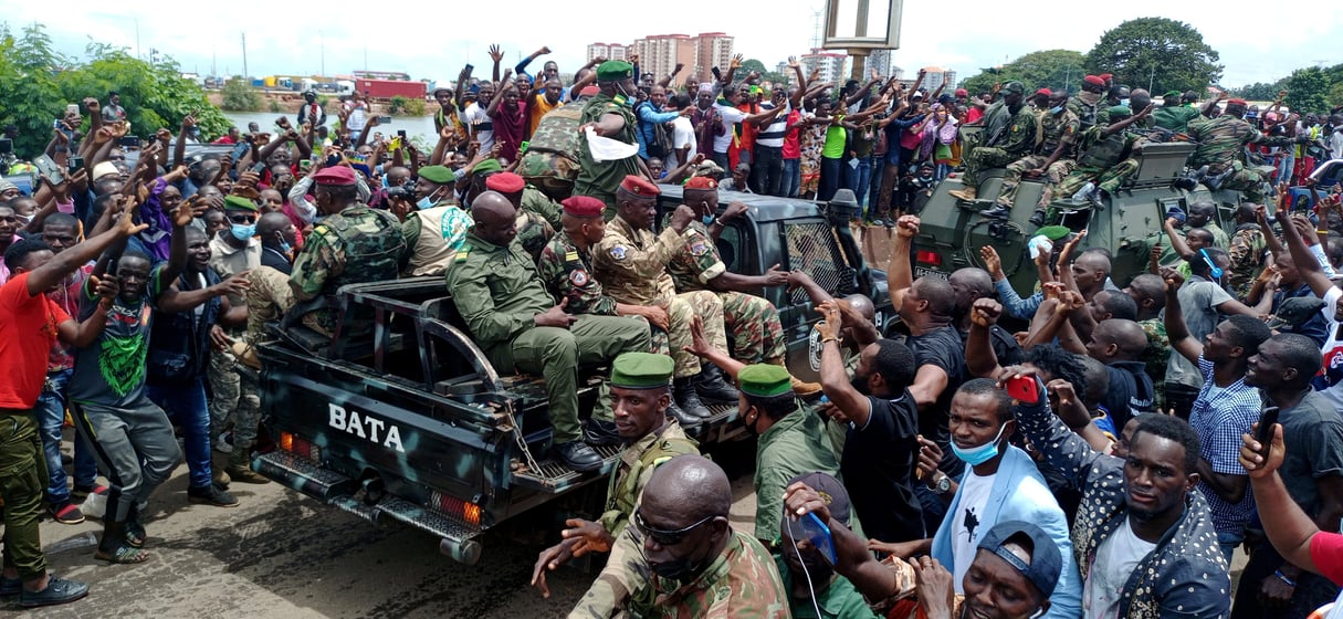 Des habitants saluent le passage des militaires putschistes, le 6 septembre à Conakry, après le coup d’État qui a fait tomber Alpha Condé. © REUTERS/Souleymane Camara