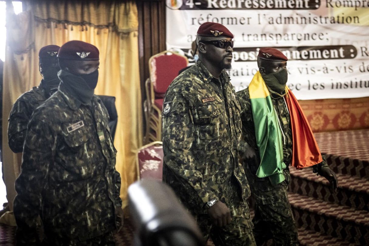Au centre, le lieutenant-colonel Mamadi Doumbouya entre dans le palais du Peuple avant la première session de pourparlers, à Conakry, le 14 septembre 2021. © JOHN WESSELS/AFP