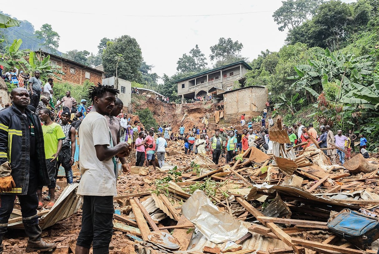 Devant des décombres dans le district de Mbankolo, au nord-ouest de Yaoundé, le 9 octobre 2023, à la suite d’un glissement de terrain provoqué par des pluies abondantes. © ETIENNE NSOM/AFP.