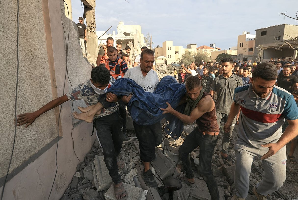 Des Palestiniens retirent un corps des décombres d’un bâtiment après une frappe israélienne à Khan Younès, dans le sud de la bande de Gaza, le 17 octobre 2023. © Mahmud HAMS/AFP