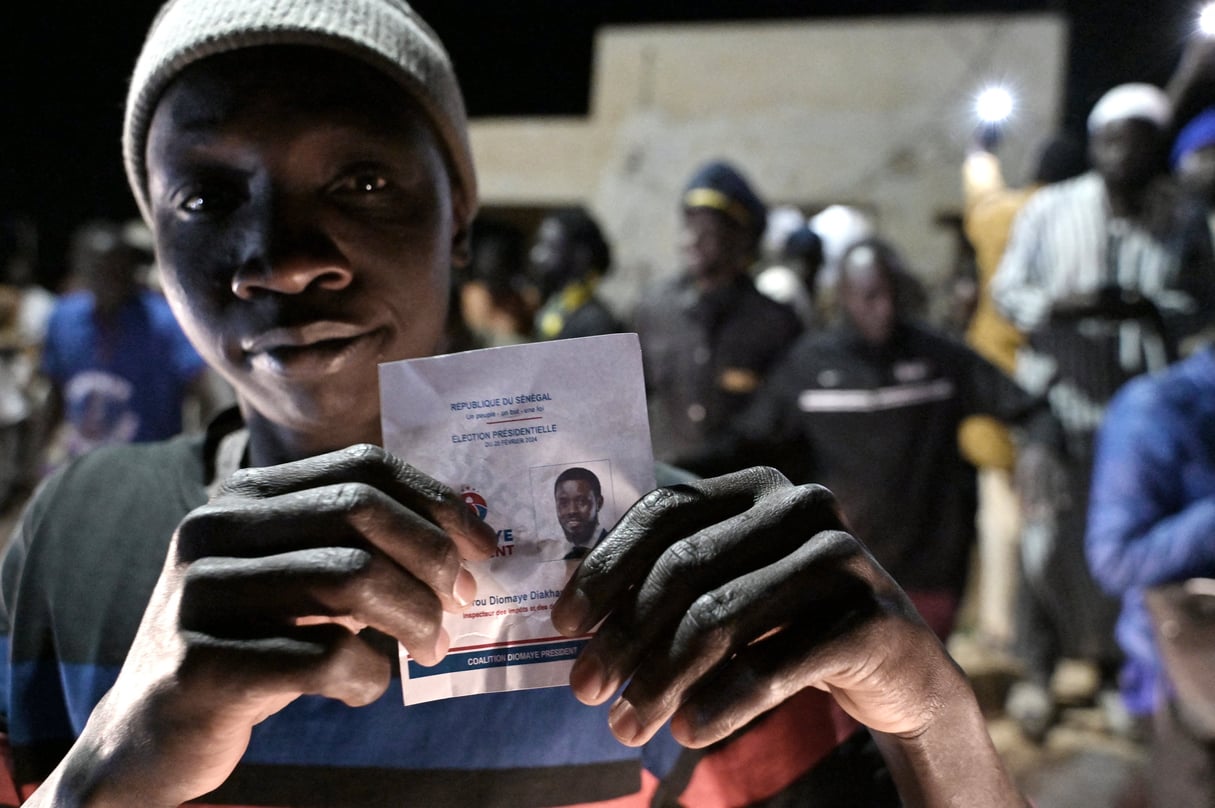 Un manifestant avec une photo du candidat présidentiel Bassirou Diomaye Faye alors qu'il célèbre la libération de ce dernier et du chef de l'opposition, Ousmane Sonko, à Dakar, le 14 mars 2024. &copy; Photo by SEYLLOU / AFP