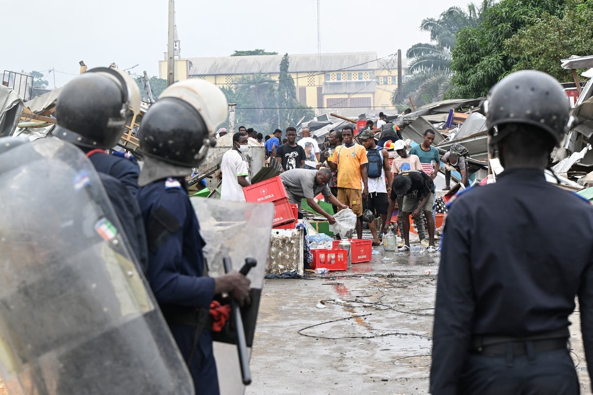 Des gendarmes et policiers ivoiriens devant des habitants après la démolition de leurs maisons situées près du 4e pont d’Abidjan, le 25 juillet 2024. © Sia Kambou / AFP