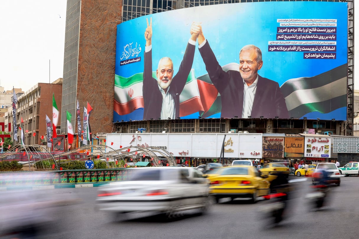 À Téhéran, un énorme panneau d’affichage représentant le président iranien Masoud Pezeshkian (à droite) et le chef du Hamas palestinien Ismail Haniyeh, le 12 août 2024. Vehicles drive past a huge billboard depicting Iranian President Masoud Pezeshkian (R) and slain Palestinian Hamas leader Ismail Haniyeh at Tehran’s Valiasr square on August 12, 2024
© ATTA KENARE/AFP