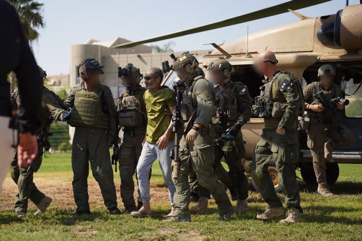 Cette photo diffusée par l’armée israélienne le 27 août 2024 montre l’otage israélien libéré Kaid Alkadi accompagné de soldats alors qu’il débarque d’un hélicoptère militaire au centre médical Soroka à Beersheva pour un bilan de santé. © Israeli Army / AFP