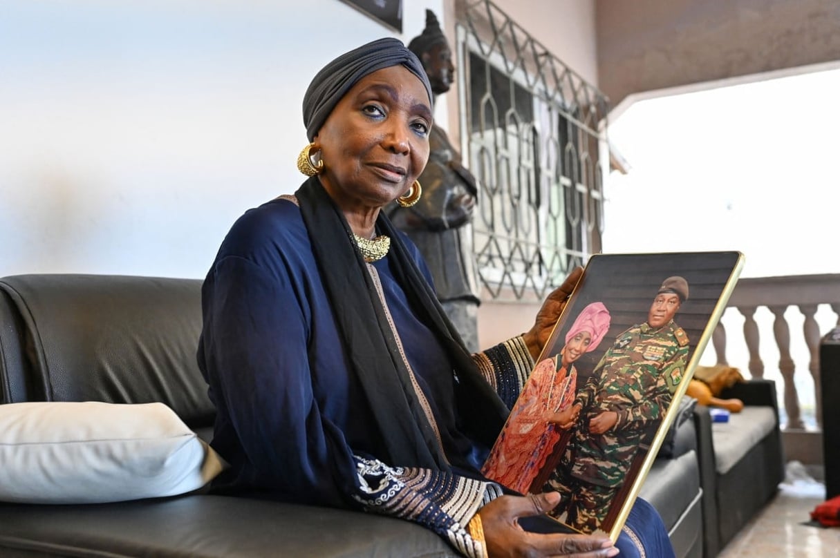 Aicha Koné avec une photo d’elle et du dirigeant du Niger, le général Abdourahamane Tiani, dans sa résidence d’Abidjan, le 13 août 2024. © Issouf SANOGO / AFP