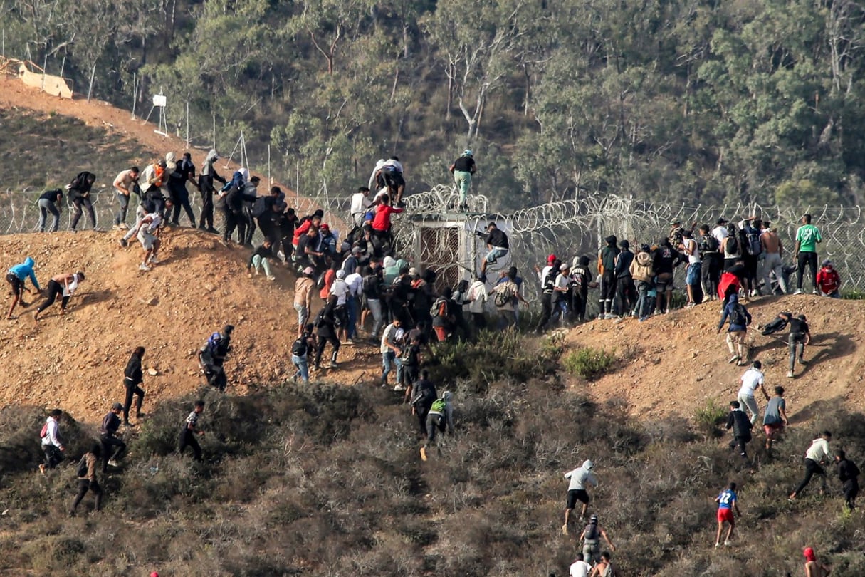 Des migrants tentent de franchir la frontière terrestre avec l’enclave africaine espagnole de Ceuta, près de Fnideq, dans le nord du Maroc, le 15 septembre 2024. © AFP