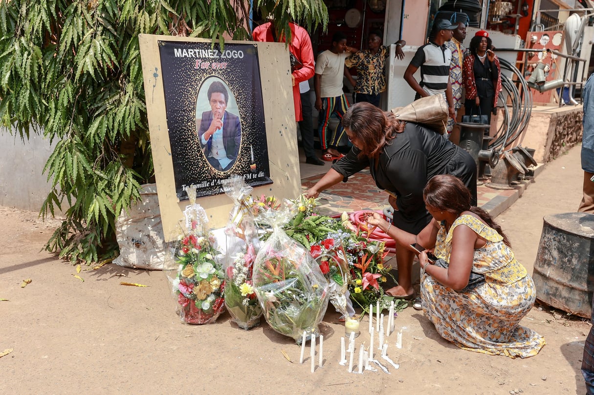 Des personnes en deuil déposent des bougies et des fleurs dans la cour de Radio Amplitude FM, lors d’une cérémonie d’hommage au journaliste Martinez Zogo, dans le quartier d’Elig Essono à Yaoundé, le 23 janvier 2023. © DANIEL BELOUMOU OLOMO/AFP