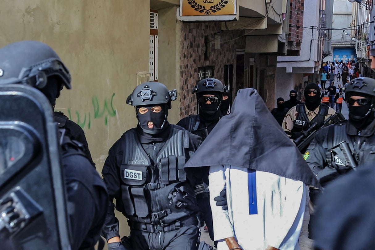 Des membres du Bureau central d’investigation judiciaire (BCIJ), qui supervise les opérations de lutte contre le terrorisme, escortent un suspect, à Tanger, le 6 octobre 2021. © AFP