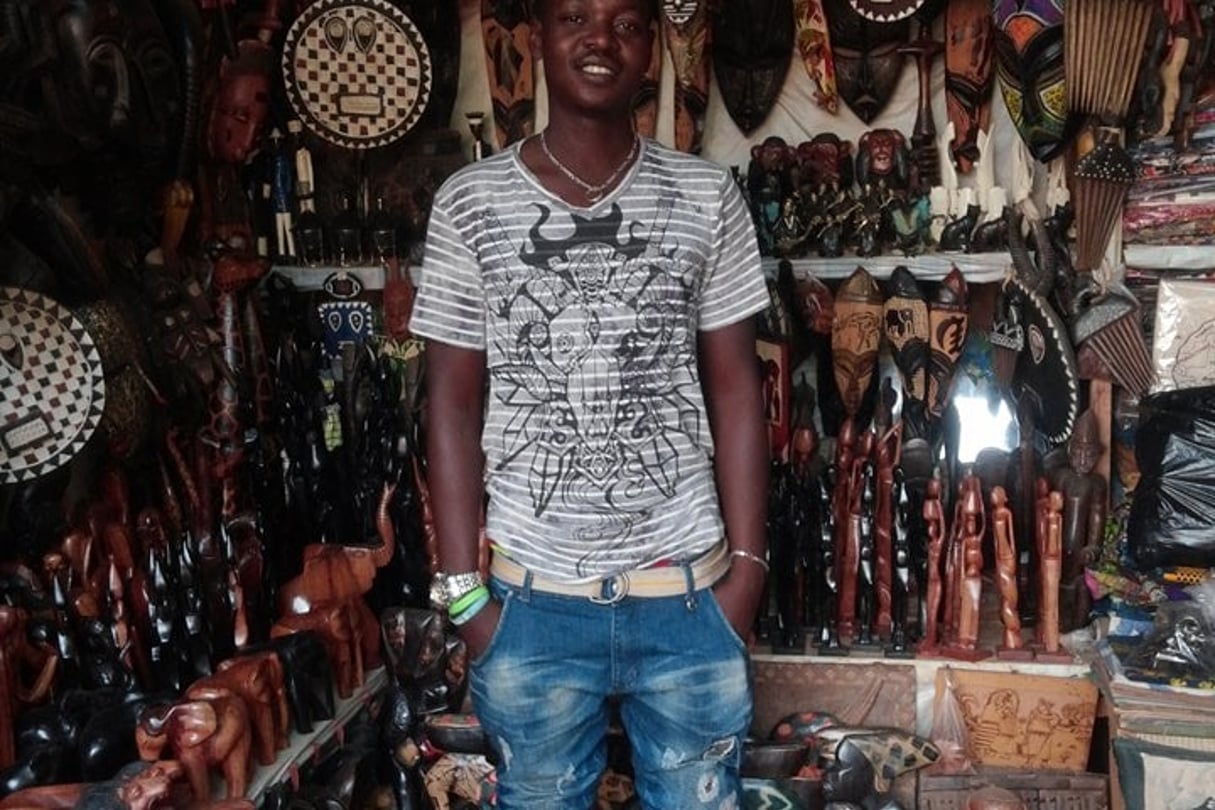 Issa au milieu des objets traditionnels qu’il vend au marché des artisans de Ouagadougou. © DR Issa Soré
