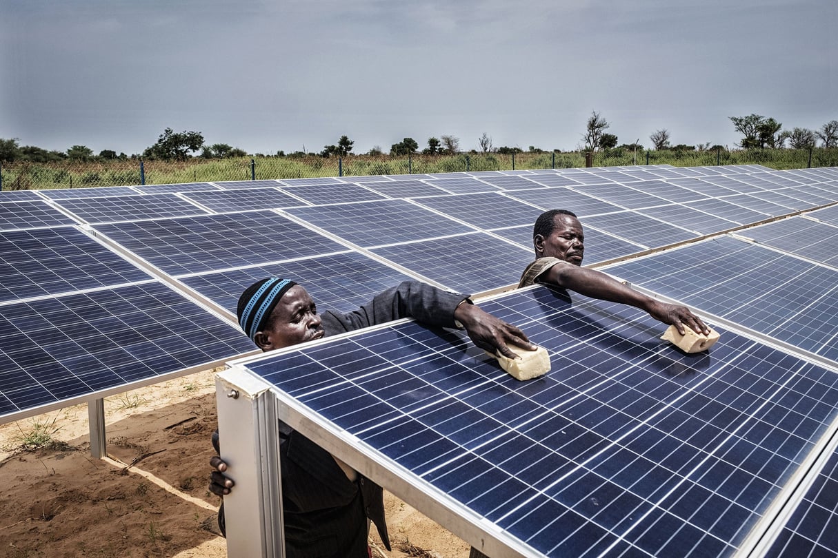 À Doumega, au Niger, des hommes nettoient les panneaux solaires que le village a achetée en commun pour fournir de l'énergie à une pompe d'irrigation alimentant ses terres agricoles. &copy; Tim Dirven / Panos-REA