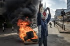 Un manifestant brandit un drapeau kenyan tout en scandant des slogans antigouvernementaux devant une barricade en feu lors d’affrontements dans le centre-ville de Nairobi, le 25 juin 2025.