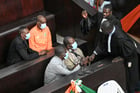 Quatre des accusés jugés pour l’attentat de Grand Bassam, dans la salle d’audience du tribunal d’Abidjan, le 22 décembre 2022. © Sia KAMBOU / AFP