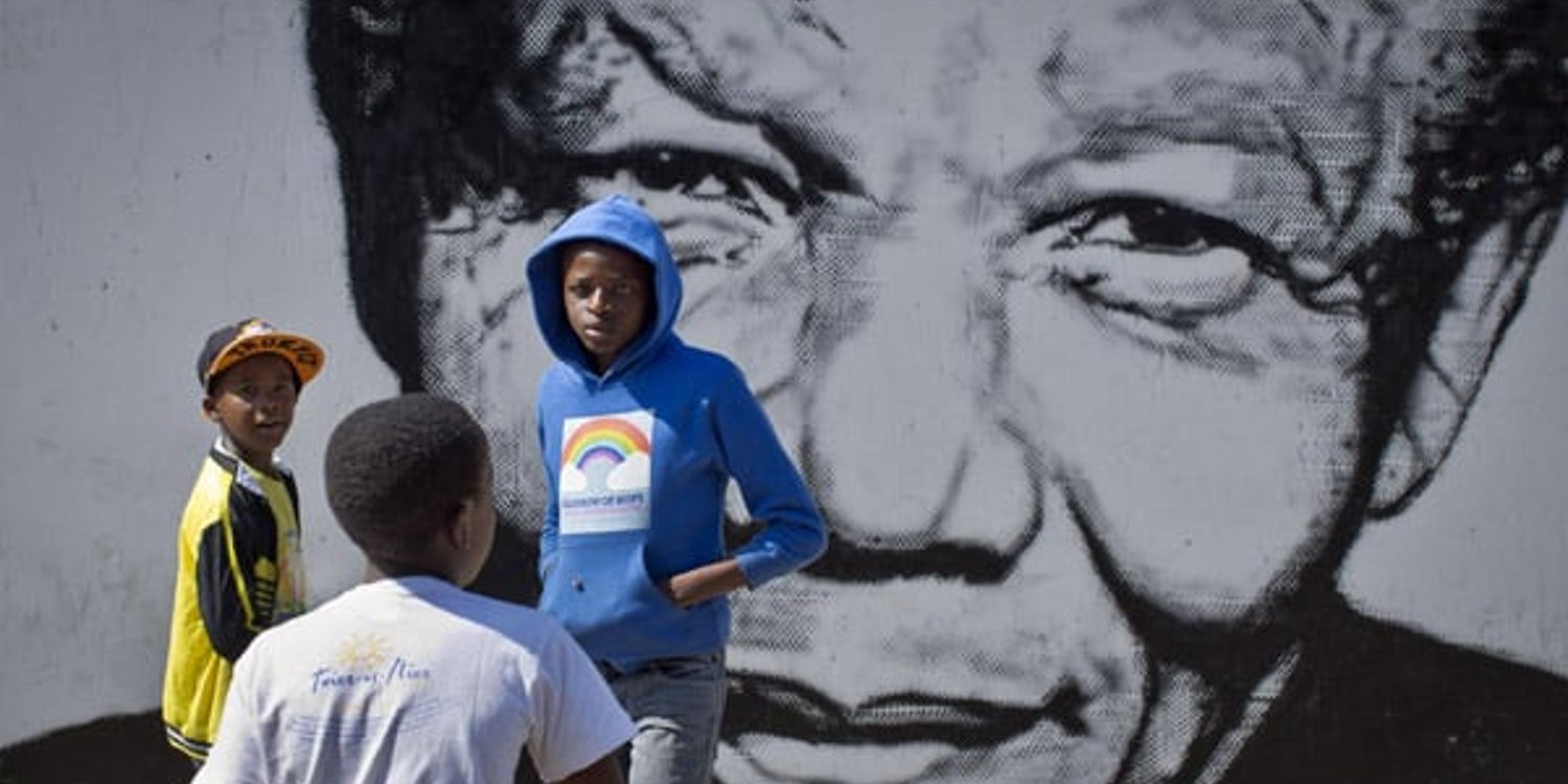 Des enfants sud-africains jouent devant une fresque murale représentant Nelson Mandela, le 2 mai 2014, dans le quartier Soweto de Johannesburg © Ben Curtis / AP / SIPA