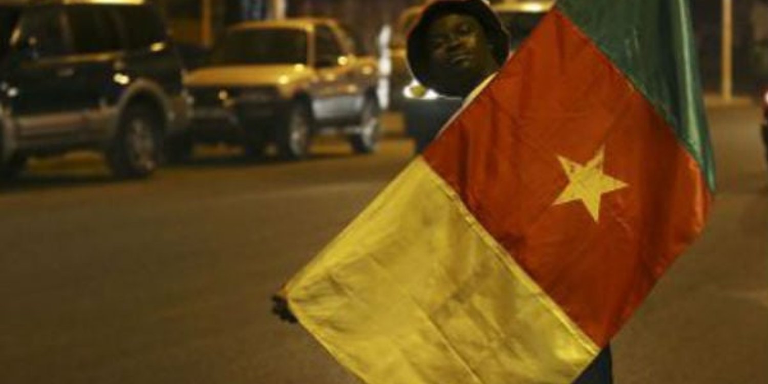 Un jeune homme tenant le drapeau du Cameroun. © Sunday Alamba/AP/SIPA