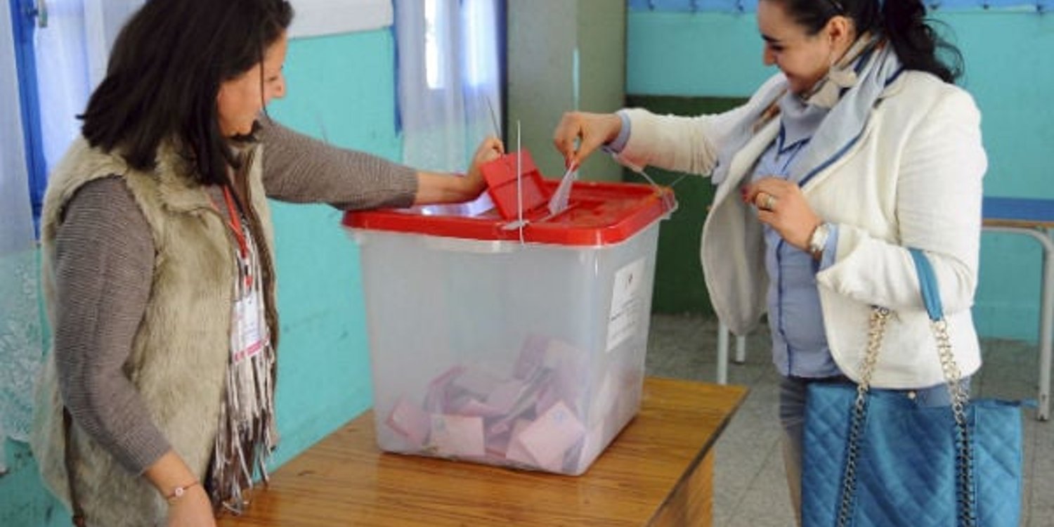 Une Tunisienne dépose son bulletin dans un bureau de vote, à La Marsa, banlieue de Tunis (Tunisie), le 21 décembre 2014. © Hassene Dridi/AP/SIPA