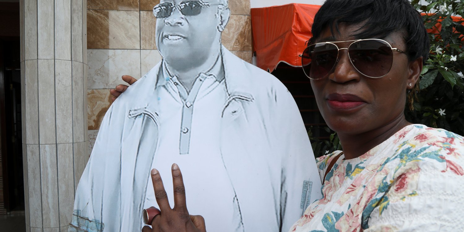 Un pro-Gbagbo pose à côté d’un portrait de l’ancien président ivoirien, au siège du FPI, le 17 juin 2021. © REUTERS/Luc Gnago