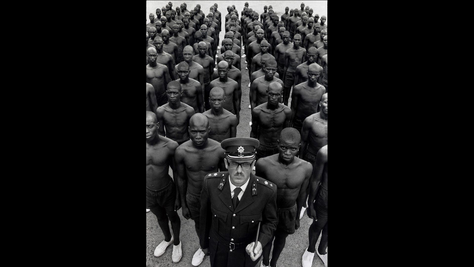 Le colonel S. J. Malan, directeur de l’école de police pour les Noirs d’Hamanskraal,  en Afrique du Sud, se tient debout devant des élèves stagiaires, en 1978. © A.Abbas / Magnum Photos.
