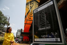 La ministre ivoirienne de la Culture, Françoise Remarck, à côté de l’affiche réalisée par l’artiste français Antonin Katre, qui évoque « La Pyramide », tour emblématique d’Abidjan, en avril 2023. © REUTERS/Luc Gnago.