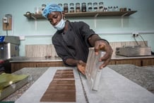 Un travailleur de la marque Moments démoule des barres de chocolat dans une usine d’Accra, le 18 juin 2019. © CRISTINA ALDEHUELA / AFP