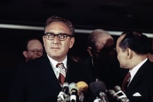 Henry Kissinger à l’aéroport d’Orly lors de son arrivée pour assister aux pourparlers de paix sur le Vietnam, le 20 novembre 1972. © AFP