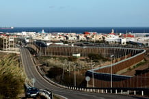 Le mur marquant la frontière entre l’enclave espagnole de Mellila et le Maroc (au loin, la ville de Nador), en février 2024. © Oscar del Pozo/AFP