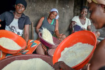 Des femmes tamisent la farine de manioc pour préparer l’attiéké, à Abidjan. © Issouf SANOGO / AFP