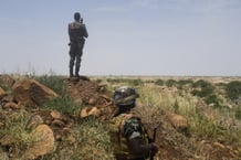 Des soldats nigériens montent la garde et patrouillent, le 10 septembre 2021 Niger’s soldiers stand guard and patrol, on September 10, 2021 near the construction site of the first dam that the country builds on the Niger river near the village of Kandadji, in the western region of the « three borders »(Niger-Mali-Burkina Faso), one of the most affected zone in Sahel by jihadist attacks. Amid the noise of the building site, armed soldiers watch over the workers, Niger is accelerating to build its first hydroelectric dam in order to stem food crises and electricity shortages, despite security threats. 
© BOUREIMA HAMA/AFP