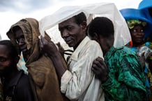 Des réfugiés de la République démocratique du Congo s’abritent de la pluie en attendant de recevoir de la nourriture. © JACK TAYLOR / GETTY IMAGES via AFP