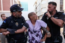 Deux policiers évacuent un homme qui voulait débattre avec les manifestants, à Torre Pacheco, dans la communauté autonome de Murcie.