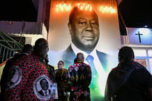 Un portrait de l’ancien président de la Côte d’Ivoire, Henri Konan Bédié, décédé le 1er août 2023, est exposé au premier jour de ses funérailles devant sa résidence d’Abidjan, le 19 mai 2024. © Issouf SANOGO / AFP