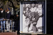Des enfants en uniforme scolaire observent l’image emblématique prise par le photographe Sam Nzima, exposée au mémorial Hector Pieterson à Soweto, en Afrique du Sud, le vendredi 16 juin 2023, alors que le pays célèbre la Journée de la jeunesse. Cette journée est célébrée chaque année en souvenir du soulèvement de 1976, lorsque les élèves ont protesté contre l’utilisation de l’afrikaans comme langue officielle d’enseignement dans les écoles de Johannesburg. © Themba Hadebe/AP/SIPA