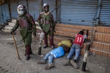 Des policiers kenyans se tiennent à côté de manifestants arrêtés qui ont été forcés de s’allonger sur le sol lors d’une manifestation, à Nairobi, le 2 juillet 2024. © LUIS TATO / AFP