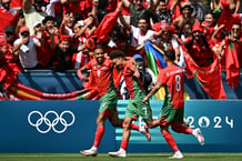 Soufiane Rahimi (g, numéro 9) après avoir marqué lors du match Argentine-Maroc, avec Eliesse Ben Seghir (c, numéro 7) et Bilal El Khannouss (8), le 24 juillet 2024, durant les JO de Paris 2024. © Arnaud Finistre / AFP