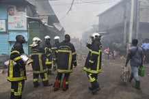 Des pompiers devant le marché d’Adjamé, le 16 août 2024. © Issouf SANOGO / AFP