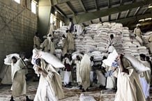 Le Programme alimentaire mondial (PAM) transporte des céréales depuis un entrepôt jusqu’à des camions, à Port-Soudan, dans l’est du Soudan, le 3 mai 2025. © Minako Sasako / The Yomiuri Shimbun via AFP