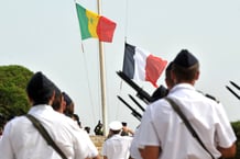 Des soldats français restent immobiles alors que le drapeau sénégalais est hissé et que le drapeau français est abaissé au camp militaire de Bel Air, à Dakar, lors d’une cérémonie le 9 juin 2010.
