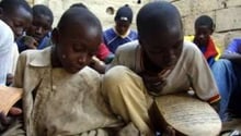 Des enfants apprennent à lire le Coran dans la cour d’une maison de Saint-Louis, le 5 janvier 2004. © AFP