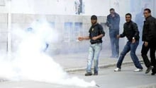 Des manifestants tunisiens reculent devant une bombe lacrymogène, le 7 avril 2012 à Tunis. © AFP