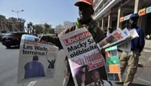 Un homme vend des journaux dans une rue de Dakar au lendemain de l’élection de Macky Sall. © AFP