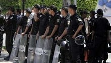 Des policiers anti-émeutes tunisiens surveillent l’avenue Bourguiba à Tunis. © AFP