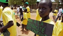 Un talibé tient une pancarte « Non à la mendicité des enfants » le 16 avril 2007 à Dakar. © AFP