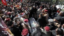 Des personnes se recueillent sur la tombe de l’opposant Chokri Belaïd. © AFP